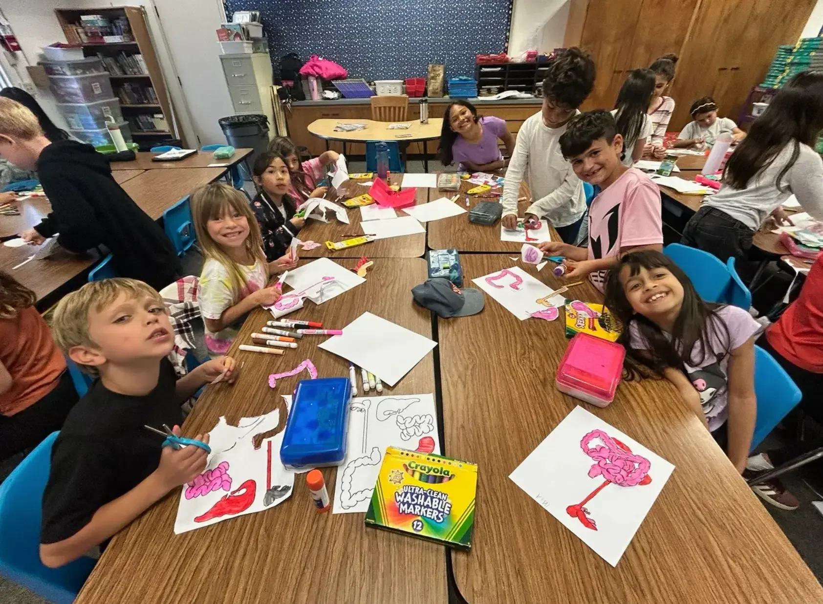 Volunteers leading a hands-on STEM activity with elementary students